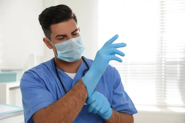 Doctor Protective Mask Putting Medical Gloves Indoors — Stock Photo, Image