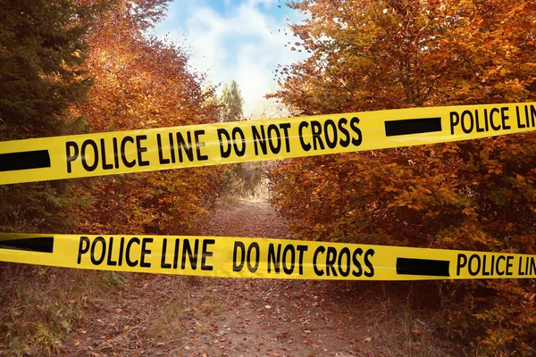 犯罪現場を隔離する黄色い警察テープ 秋の公園の制限区域 — ストック写真