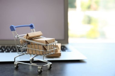 İnternet alışverişi. Modern dizüstü bilgisayarın yanında kutuları olan küçük bir araba.