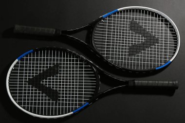 Siyah arka planda tenis raketleri, düz yatış. Spor malzemeleri.