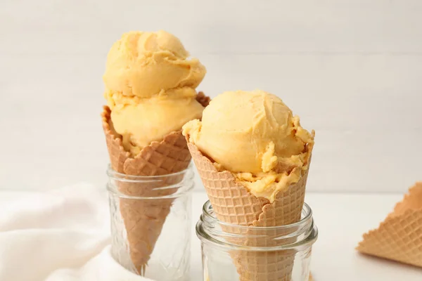 精美的黄色冰淇淋 放在圆锥上 玻璃瓶放在桌子上 特写镜头 — 图库照片