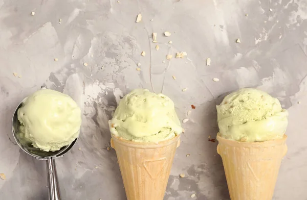 薄緑色のテーブルの上のウエハーコーンのおいしいピスタチオアイスクリーム フラットレイ テキストのスペース — ストック写真