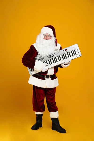 Święty Mikołaj Syntezatorem Żółtym Tle Muzyka Świąteczna — Zdjęcie stockowe