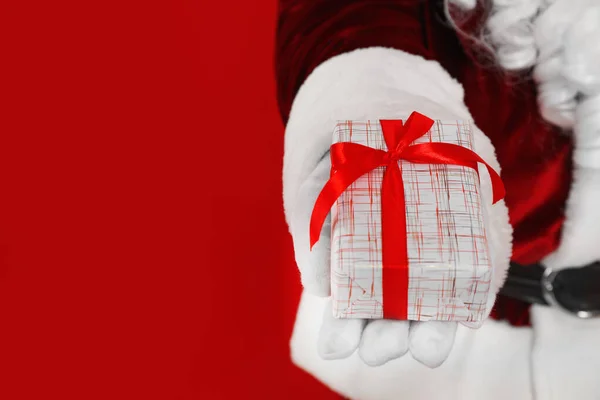 Santa Claus Sosteniendo Regalo Navidad Sobre Fondo Rojo Primer Plano —  Fotos de Stock