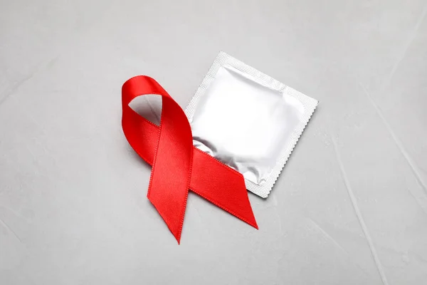 Rött Band Och Kondom Ljusgrå Sten Bakgrund Ovanifrån Medvetenhet Aids — Stockfoto