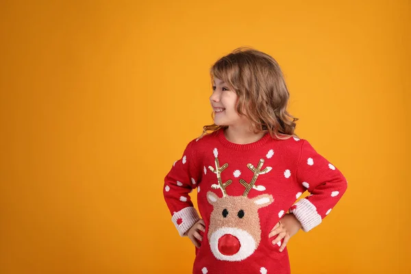 Cute Little Girl Red Christmas Sweater Smiling Orange Background Space — Stock Photo, Image