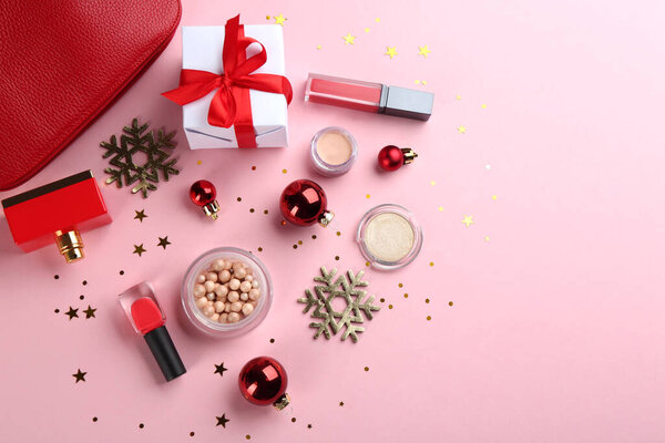 Flat lay composition with decorative cosmetic products on pink background. Winter care
