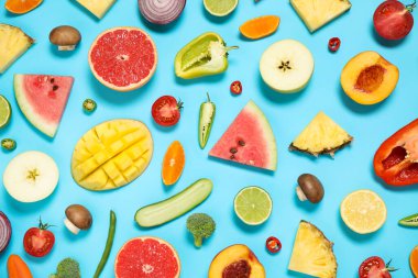 Açık mavi zemin üzerinde taze organik meyve ve sebzelerle bezenmiş düz bir kompozisyon.