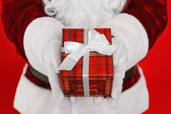 Santa Claus Holding Christmas Gift Red Background Closeup — Stock Photo, Image