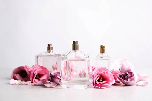 Бутылки Духов Красивые Цветы Светлом Столе — стоковое фото