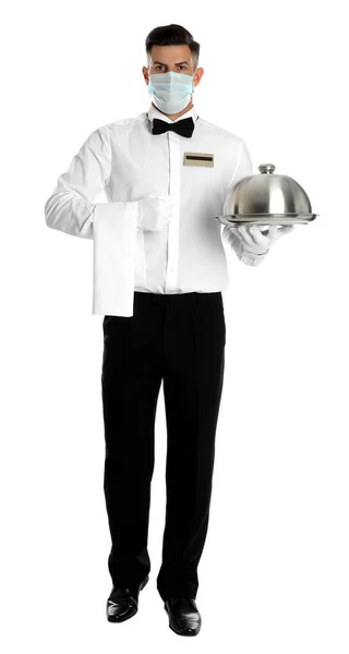 Waiter in medical face mask holding tray with lid on white background