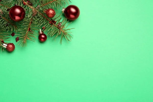 光沢のあるクリスマスボールと緑の背景にコンフェッティとフェアブランチ フラットレイアウト テキストのスペース — ストック写真