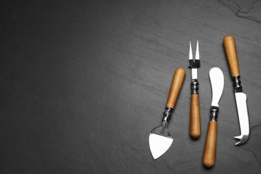 Peynir bıçakları ve çatal siyah taş masaya, düz yatıyordu. Metin için boşluk