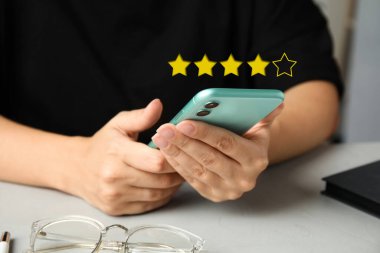İncelemeyi masadaki akıllı telefondan yapan kadın, kapatıyor. Beş yıldızdan dördü bir aletin üstünde.
