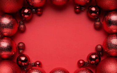 Kırmızı arka planda noel topları çerçevesi, düz yatış. Metin için boşluk