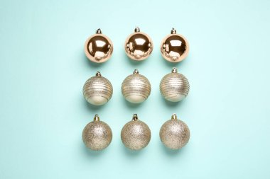 Açık mavi arka planda parlak Noel topları, düz uzanmış