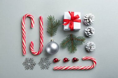 Gri arka planda şeker kamışı ve Noel dekoru olan düz bir kompozisyon