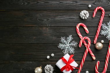 Siyah ahşap masanın üzerinde şeker kamışı ve Noel dekoru olan düz bir kompozisyon vardı. Metin için boşluk