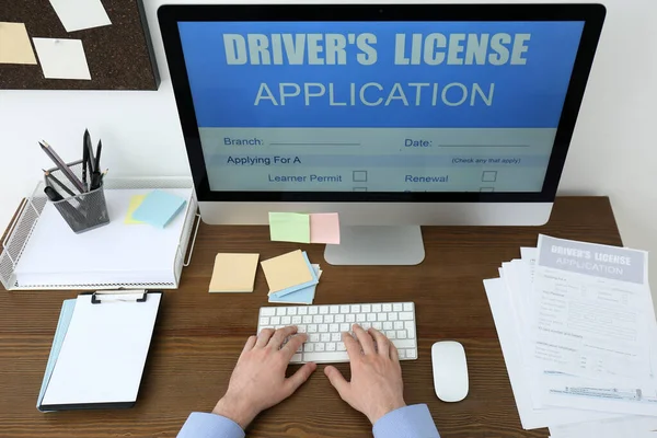 Man Met Behulp Van Computer Vullen Rijbewijs Aanvraagformulier Aan Tafel — Stockfoto