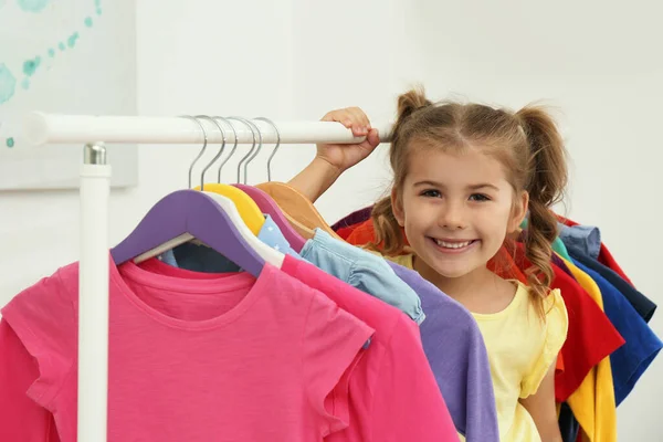 Mała Dziewczynka Wybierając Ubrania Stojaku Pomieszczeniach — Zdjęcie stockowe