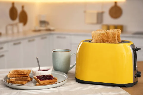 现代烤面包机和美味的早餐放在厨房的木制桌子上 — 图库照片