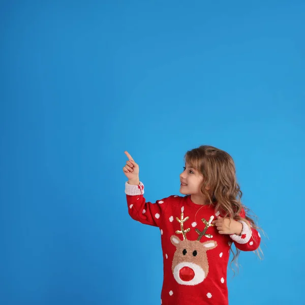 Cute Little Girl Red Christmas Sweater Pointing Blue Background Space — Stock Photo, Image
