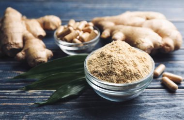 Kuru, taze ve kapsüllü zencefil mavi ahşap masada.