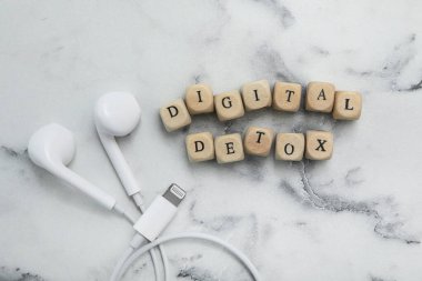 Dijital detoks ve kulaklık içeren küpleri beyaz mermer masa, düz yatıyordu