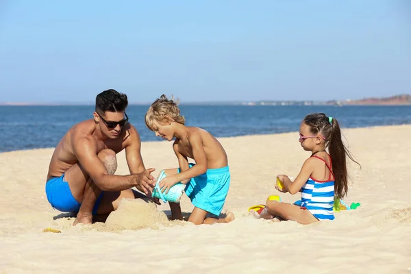 Padre Hijos Jugando Playa Arena Cerca Del Mar Vacaciones Verano —  Fotos de Stock