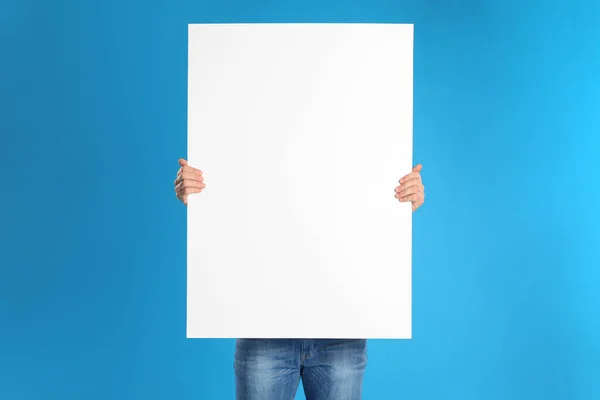 Man Holding Blank Poster Blue Background — Stock Photo, Image