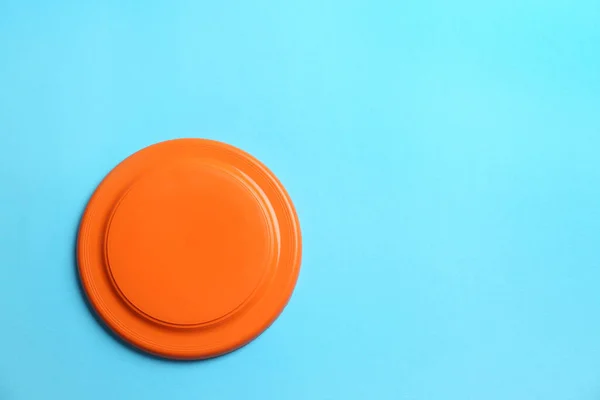 Pomarańczowy Plastikowy Dysk Frisbee Jasnoniebieskim Tle Widok Góry Miejsce Tekst — Zdjęcie stockowe