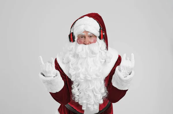 Weihnachtsmann Mit Kopfhörer Hört Weihnachtsmusik Auf Hellgrauem Hintergrund — Stockfoto