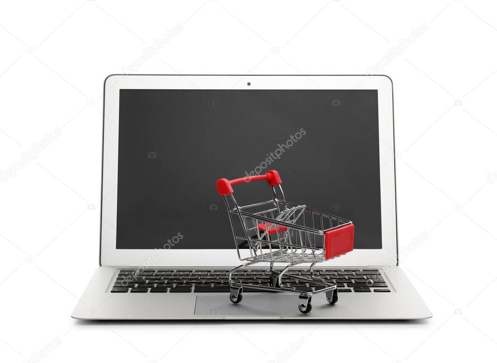 Internet shopping. Laptop with small cart isolated on white