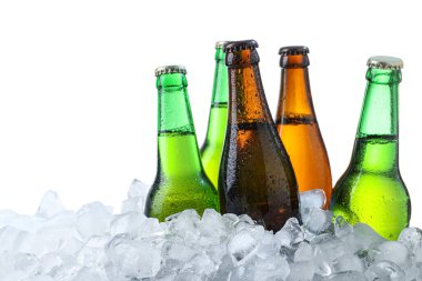 Beyaz arka planda buz küpleri üzerinde bira şişeleri