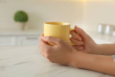 Masada sarı bardaklı kadın, yakın plan.