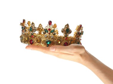 Beyaz arka planda altın kaplama güzel bir taç tutan kadın, yakın plan. Fantezi ögesi