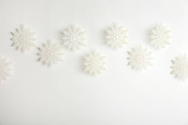 Beyaz arkaplanda asılı güzel dekoratif kar taneleri, metin için boşluk