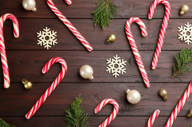 Düz kompozisyon, baston şekerler ve ahşap masa üzerine Noel süsü.