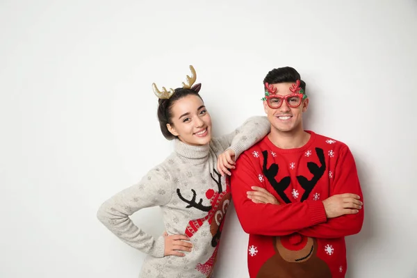 Para Świątecznych Swetrach Opasce Jelenie Okularach Imprezowych Białym Tle — Zdjęcie stockowe