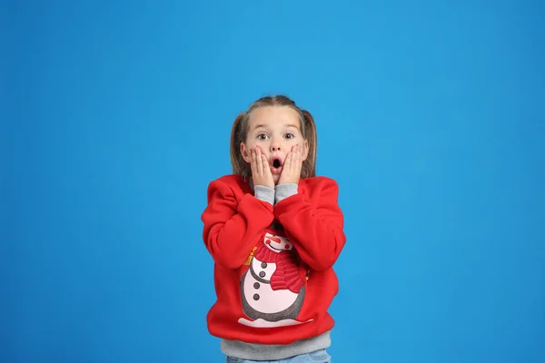 Zaskoczona Dziewczynka Świątecznym Swetrze Niebieskim Tle — Zdjęcie stockowe