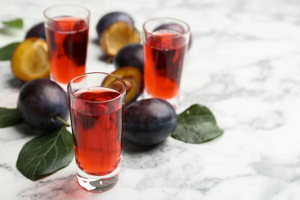 美味的李子酒和成熟的水果放在白桌上 国产烈性酒 — 图库照片