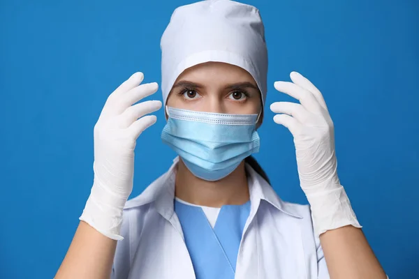 Dokter Beschermend Masker Medische Handschoenen Tegen Blauwe Achtergrond — Stockfoto