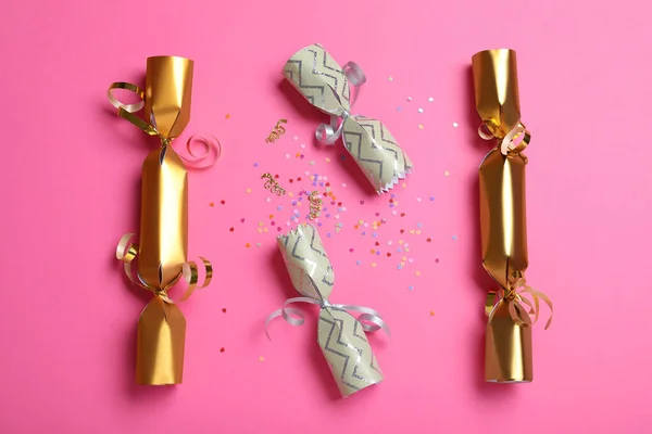Open Gesloten Kerst Crackers Met Glanzende Confetti Roze Achtergrond Plat — Stockfoto