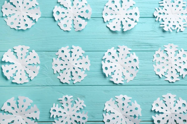 Viele Papierschneeflocken Auf Türkisfarbenem Holzgrund Flache Lage — Stockfoto