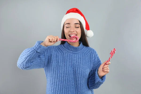 Ung Kvinna Blå Tröja Och Santa Hatt Äta Godis Käppar — Stockfoto