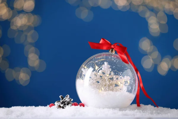 Bola Nieve Decorativa Con Cinta Roja Contra Luces Festivas Borrosas —  Fotos de Stock