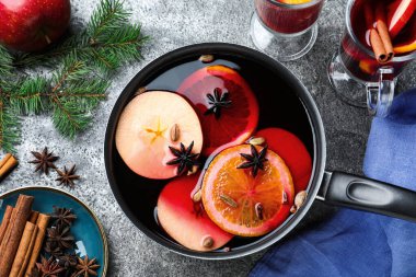 Lezzetli sıcak şarap ve malzemeler gri masada, düz yatıyordu.