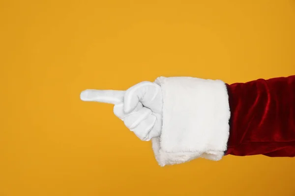 Święty Mikołaj Wskazujący Coś Żółtym Tle Zbliżenie Dłoni — Zdjęcie stockowe