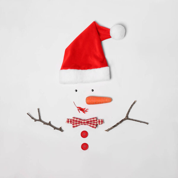 Творческая форма снеговика из шляпы Санта-Клауса и различных предметов на белом фоне, плоская
