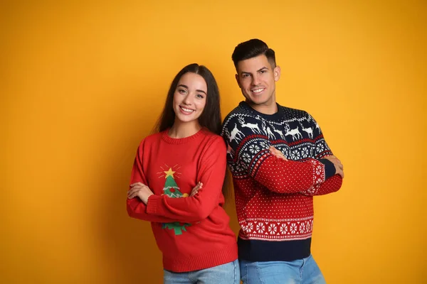 Sarı Arka Planda Bir Çift Noel Süveteri Giyiyor — Stok fotoğraf